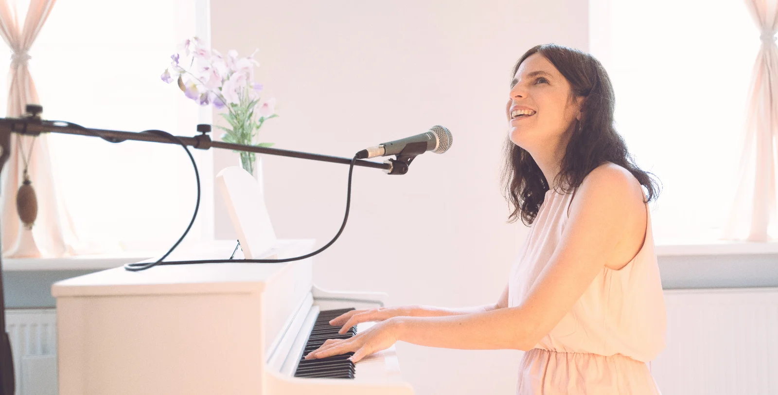 Magdalena singt und spielt am weißen Klavier